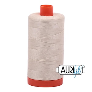 May include: A spool of light beige sewing thread featuring a bright orange plastic top and bottom cap. The spool is wrapped in smooth, tightly wound thread and includes a white rectangular logo with the black text AuriFil on the side.