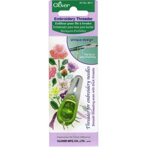 May include: A package for an embroidery threader, featuring a green and clear plastic tool. The packaging is purple and white, with text in multiple languages. The threader has a flat tip for easy threading and is designed for thick threads.