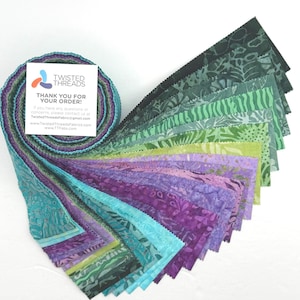 May include: A jelly roll fabric bundle featuring a gradient of batik strips in shades of teal, purple, and green. The fabric strips are rolled into a spiral and fanned out, displaying various patterns. A white card with the text TWISTED THREADS is included.