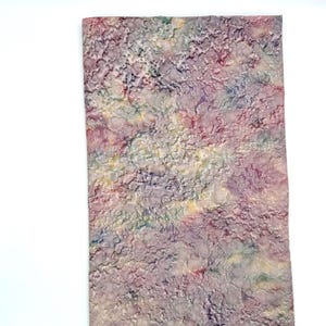 May include: A rectangular piece of paper with a textured, mottled surface. The colors include shades of purple, pink, yellow, green, and blue. The paper has a unique, organic appearance, with a pattern of raised, irregular shapes.