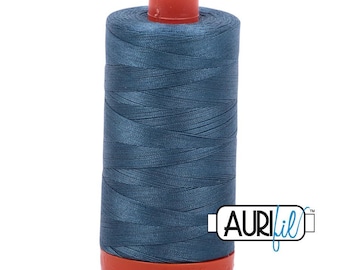 Op de afbeelding: Een klos donkerblauw naaigaren met een rode plastic dop aan de boven- en onderkant. De draad is strak om de cilindrische kern gewikkeld. Een wit rechthoekig logo met de zwarte tekst AURIfil bevindt zich rechtsonder op de klos.