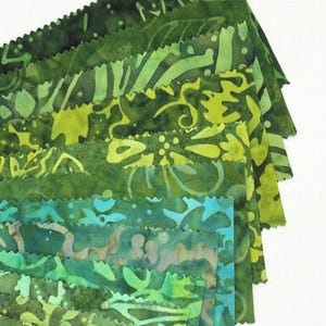 May include: A collection of green fabric swatches with various patterns and shades, ranging from dark forest green to bright lime. The edges of the fabric are cut with a decorative, zigzag pattern. The fabrics have a batik-like appearance.