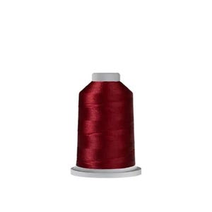 May include: A spool of deep burgundy sewing thread featuring a smooth, lustrous finish. The thread is tightly wound around a cylindrical plastic core with a white base and a white top cap, creating a uniform and compact shape for storage.
