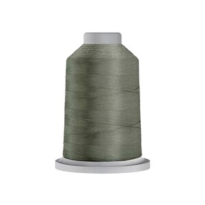 May include: A spool of sage green sewing thread featuring a cylindrical shape with a flat top and a wider base. The thread is tightly wound around the central core, displaying a smooth, consistent texture and a muted, earthy green color throughout.