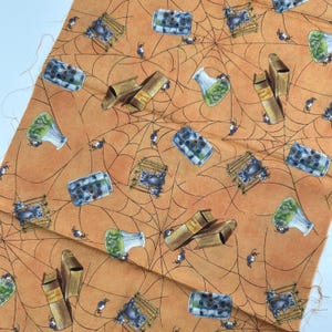 May include: Orange fabric with a Halloween-themed pattern. The design includes spiderwebs, spiders, potion bottles, books, and cages with skulls. The fabric is suitable for crafting projects.