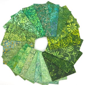 May include: A circular arrangement of rectangular fabric swatches featuring various shades of green. Each piece displays distinct batik-style patterns, including floral motifs, leafy vines, geometric shapes, and abstract textures in lime, forest, and emerald.