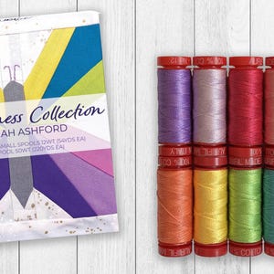 May include: A set of ten spools of thread in various colors including purple, pink, red, peach, teal, orange, yellow, lime green, light blue, and grey, accompanied by a product box labeled The Wellness Collection by Sarah Ashford 100% cotton.