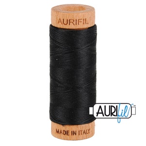 May include: A spool of black thread with a wooden bobbin. The bobbin is labeled "Aurifil" and "Made in Italy".