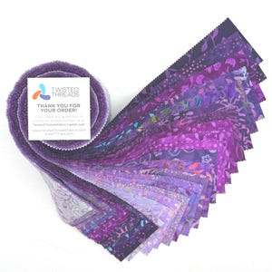 May include: A jelly roll of fabric strips in various shades of purple, ranging from light lavender to deep violet, featuring diverse patterns. A square white card is attached to the roll with the text TWISTED THREADS THANK YOU FOR YOUR ORDER.