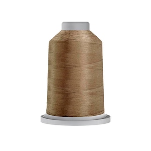May include: A spool of light brown sewing thread wound onto a cylindrical plastic core. The thread features a smooth, consistent texture and a subtle sheen, wrapped tightly around the central spool structure with a flat base and top.