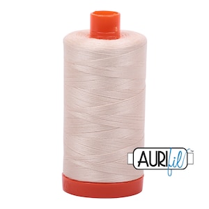 May include: A spool of pale pink thread with an orange plastic bobbin and the text "Aurifil" in blue.