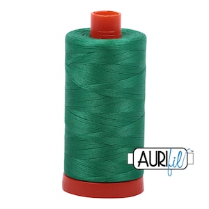 May include: A spool of green thread with a red top and bottom. The spool is labeled "Aurifil" in a blue box.