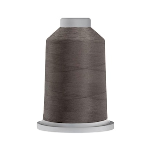 May include: A spool of dark gray sewing thread featuring a cylindrical shape with a flat top and a wider circular base. The thread is tightly wound around the central core, displaying a smooth, consistent texture and a deep, neutral charcoal color.