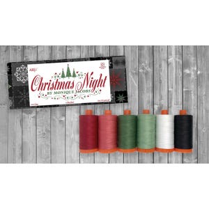 May include: A set of six spools of thread in shades of dark red, light red, dark green, light green, white, and black, accompanied by a rectangular product label featuring the text Christmas Night by Monique Jacobs and green tree graphics.