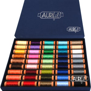 May include: A blue box filled with 40 spools of Aurifil thread. The spools are arranged in rows and are in a variety of colors, including red, green, blue, yellow, and pink. The box is labeled "Aurifil" in silver lettering.