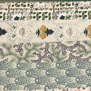 May include: Close-up of a fabric with various patterns in shades of green, beige, and gold. The design includes floral, leaf, and geometric motifs arranged in horizontal stripes. The fabric has a vintage or antique aesthetic.