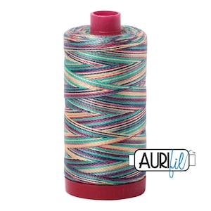 May include: A spool of multi-colored thread with a red plastic bobbin. The thread is a mix of teal, pink, cream, and navy blue. The spool is labeled "Aurifil" in blue lettering.