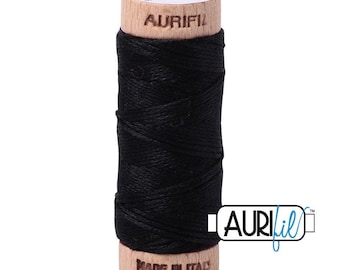 May include: A spool of black sewing thread wrapped around a light-colored wooden core. The top of the wooden spool is stamped with the text AURIFIL and the number 2692, while the bottom is stamped with the text MADE IN ITALY.