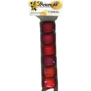 May include: A package of six spools of red thread in varying shades, from deep burgundy to bright red. The thread is tightly wound and packaged in a clear plastic sleeve. The label at the top reads "Presencia Hilaturas USA".