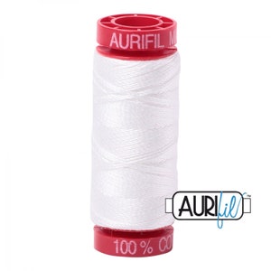 May include: A spool of white Aurifil thread with a red plastic bobbin and the text "Aurifil 100% Cotton" on the bottom.