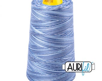 May include: A large spool of sewing thread featuring a variegated pattern of light blue, medium blue, and dark blue horizontal stripes. The spool has a bright yellow top cap with the text Auri fil printed in black. The Auri fil logo is visible.