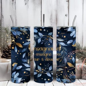 May include: Three navy blue insulated tumblers with a floral design featuring blue and gold leaves and the text "Enseigner avec coeur & douceur". Each tumbler has a silver straw.