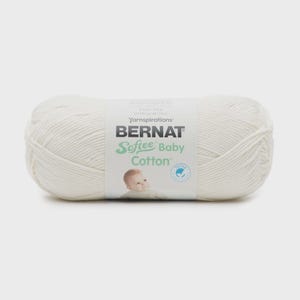 Puede incluir: Un ovillo de hilo de algodón color blanco roto Bernat Softee Baby con una etiqueta central de papel. La etiqueta muestra el nombre de la marca, el nombre del producto, la imagen de un bebé y el peso de 120 g impreso en el frente.