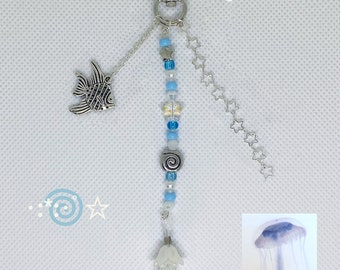 May include: A silver star charm with a blue and white beaded keychain featuring a silver fish charm and a white jellyfish charm. The keychain has a silver chain with star charms.
