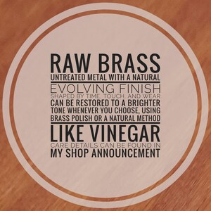 May include: A circular graphic with a light beige background and a dark brown border containing the text: RAW BRASS UNTREATED METAL WITH A NATURAL EVOLVING FINISH SHAPED BY TIME, TOUCH, AND WEAR CAN BE RESTORED TO A BRIGHTER TONE USING BRASS POLISH OR VINEGAR.