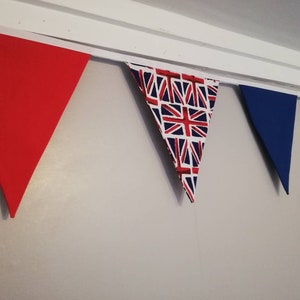 May include: A bunting with red, white and blue triangular flags. The flags have a Union Jack pattern.