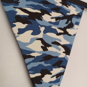 Puede incluir: Un bander&iacute;n de tela de camuflaje azul, negro y blanco con borde negro.