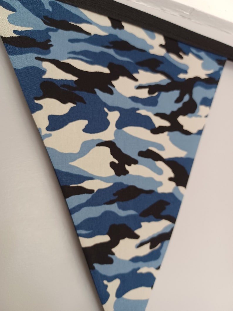 Puede incluir: Un bander&iacute;n de tela de camuflaje azul, negro y blanco con borde negro.