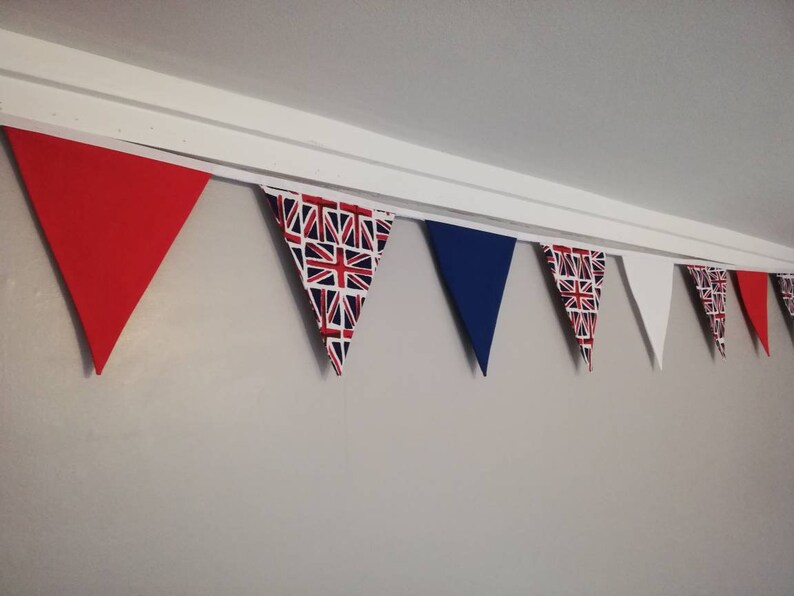 May include: A bunting with red, blue and white triangular flags. The flags have a Union Jack pattern.