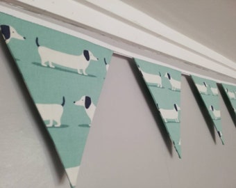 Sausage dog bunting - white dogs on a soft duck egg blue or yellow ochre background fabric. #sausagedoggifts #sausagedog