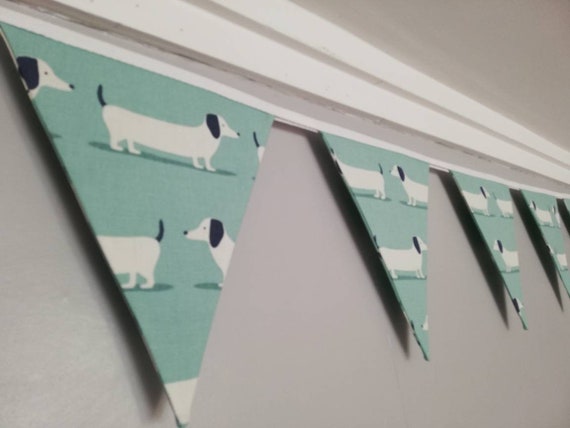Sausage dog bunting - white dogs on a soft duck egg blue or yellow ochre background fabric. #sausagedoggifts #sausagedog