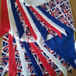 May include: A bunting string with multiple triangular flags. The flags are made of fabric and feature a repeating pattern of the Union Jack flag in red, white, and blue.