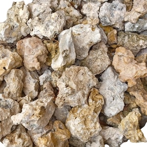 May include: A close-up of a pile of rough, light brown and white rocks. The rocks have a variety of shapes and sizes, and some have a slightly textured surface.