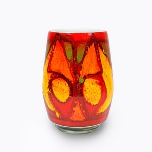 May include: A red ceramic vase with a geometric pattern in shades of orange, yellow, and green.