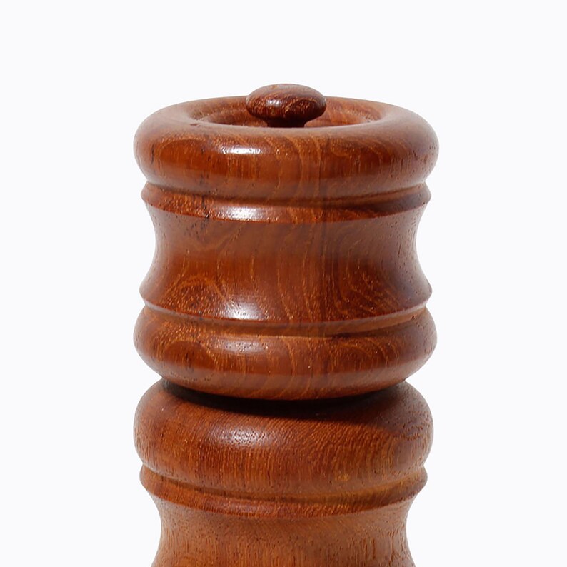 May include: A wooden salt and pepper shaker set with a rounded, cylindrical shape. The shakers are made of dark brown wood with a smooth, polished finish.
