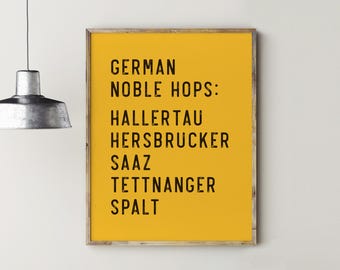 May include: A yellow poster with a wooden frame, listing German Noble Hops: Hallertau, Hersbrucker, Saaz, Tettnanger, Spalt.