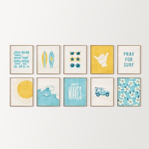 May include: Nine framed prints with a beach theme. The prints feature images of surfboards, sunglasses, waves, a sun, a hand making a shaka sign, a car with a surfboard on top, and a floral pattern. The prints are all in shades of blue and yellow.