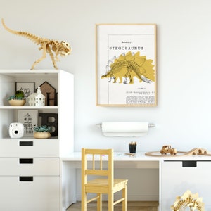 May include: A framed illustration of a Stegosaurus skeleton in yellow on a white background. The text "Illustration of Stegosaurus" is at the top of the frame. The illustration is in a child's room with a wooden dinosaur toy, a shelf with books and plants, and a desk with a chair.