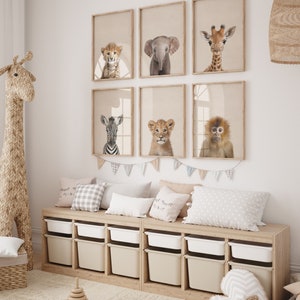 Peut inclure: Une chambre d'enfant avec un banc de rangement en bois avec des bacs de rangement beige et blanc. Le mur est d&eacute;cor&eacute; de six tirages d'animaux encadr&eacute;s d'un gu&eacute;pard, d'un &eacute;l&eacute;phant, d'une girafe, d'un z&egrave;bre, d'un lion et d'un singe. La pi&egrave;ce comprend &eacute;galement un jouet girafe en osier, un jouet d'empilage en bois et un panier en osier.