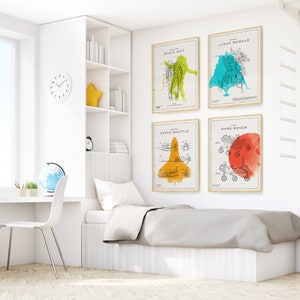 May include: A white bedroom with a white bed, a desk, and a bookshelf. There are four framed prints on the wall with illustrations of space-related objects, including a space suit, a lunar module, a space shuttle, and a Mars rover. The prints have watercolor backgrounds in shades of yellow, green, orange, and red.