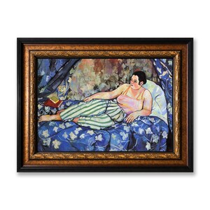May include: A framed oil painting depicting a person reclining on a blue floral patterned bedspread. The figure wears a light-colored tank top and green and white striped trousers, resting against a white pillow with a small book nearby.