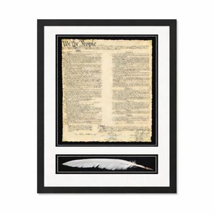 May include: Framed print of the U.S. Constitution with the words "We the People" at the top. Below the document is a white feather on a black background. The frame is black with a white mat.