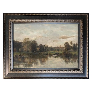 May include: An antique landscape painting in a dark, ornate frame. The artwork depicts a serene river scene with trees lining the banks and a cloudy sky overhead. The painting's colors are muted, with browns, greens, and blues dominating the palette.