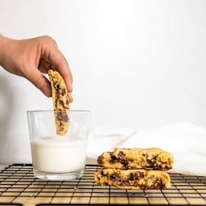 Vegan Gluten Free Chocolate Chip Cookie Being Dunked in Milk