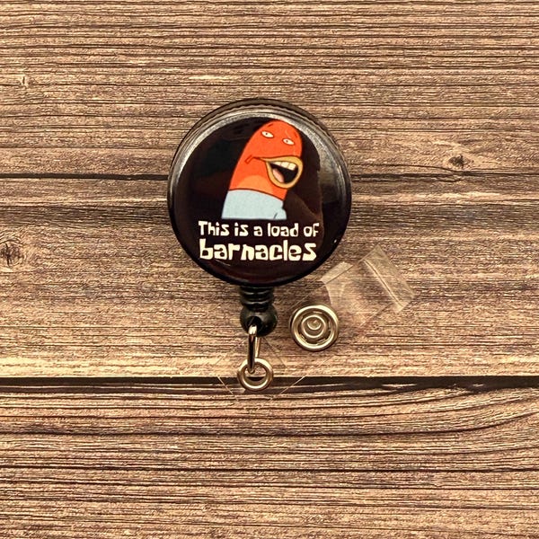 May include: A black retractable badge reel with a cartoon image of a red creature with a wide grin. The text "This is a load of barnacles" is printed in white on the reel.