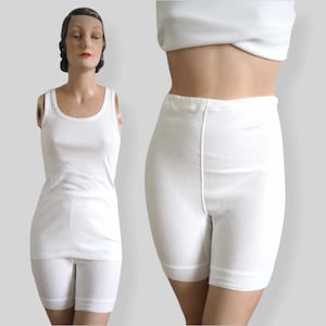 May include: White cotton tank top and matching shorts. The tank top has a scoop neck and the shorts have a wide waistband.
